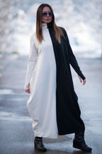 Woman wearing a long black and white dress with sunglasses in a snowy landscape