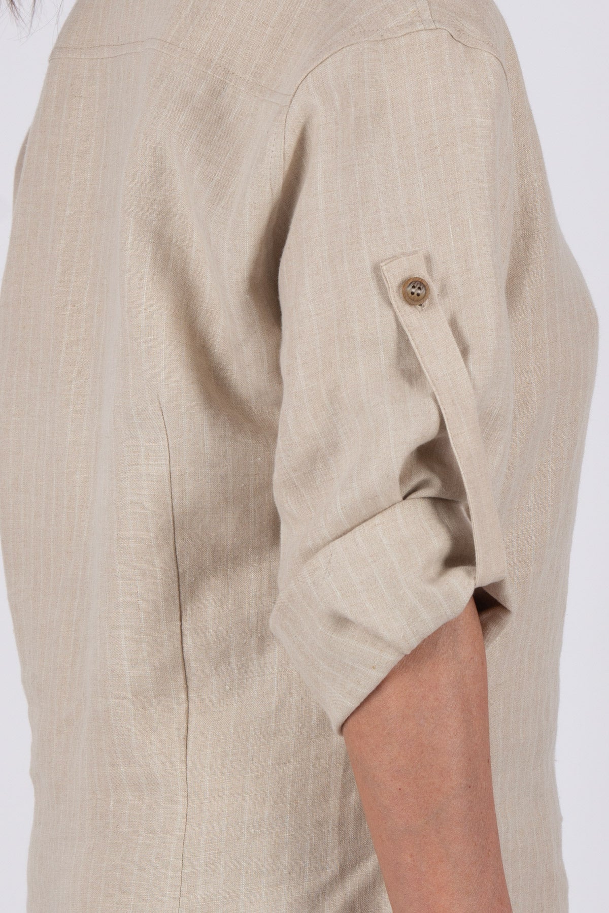 Beige linen shirt with rolled-up sleeves on a white background