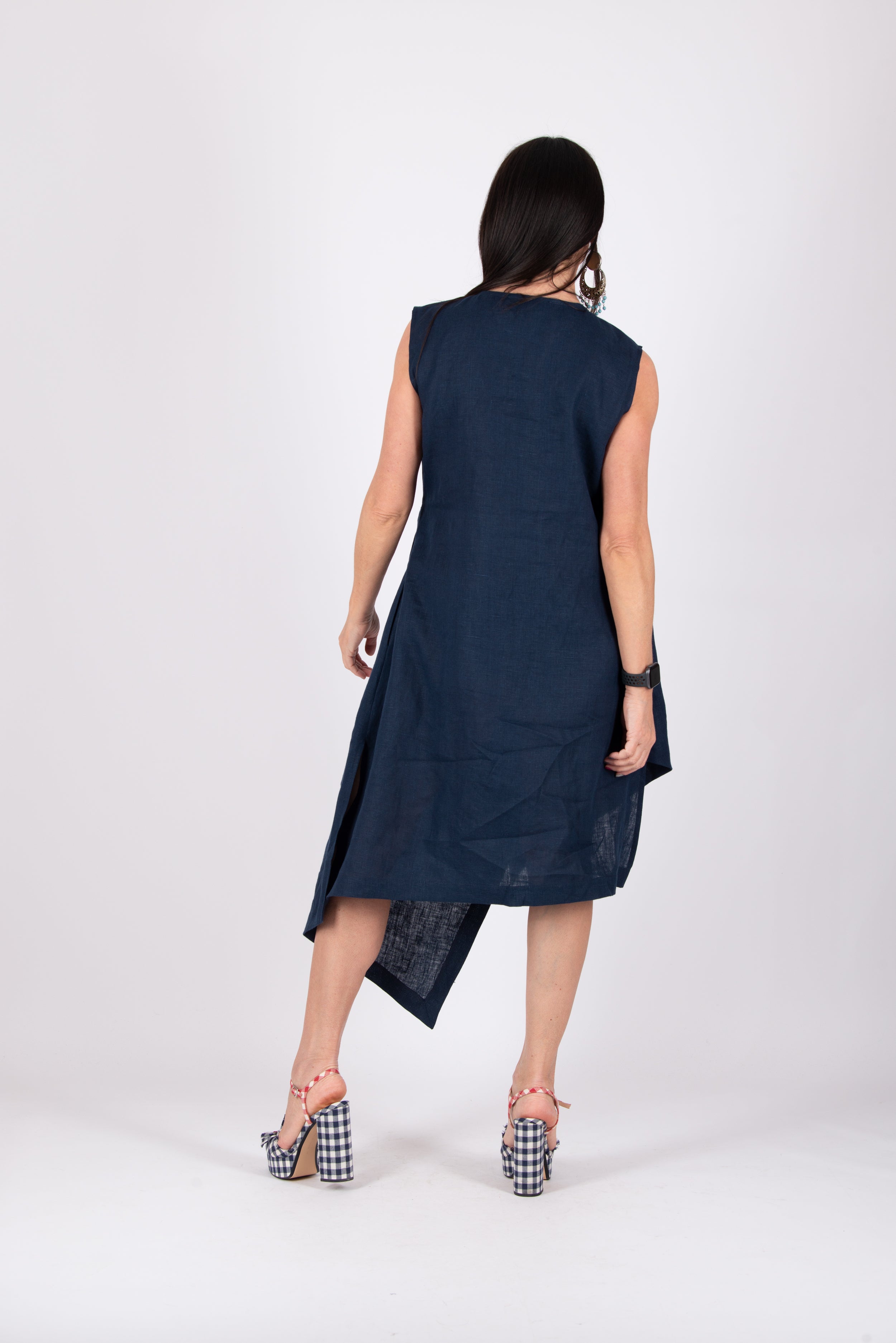 Woman wearing a navy blue sleeveless dress on a white background