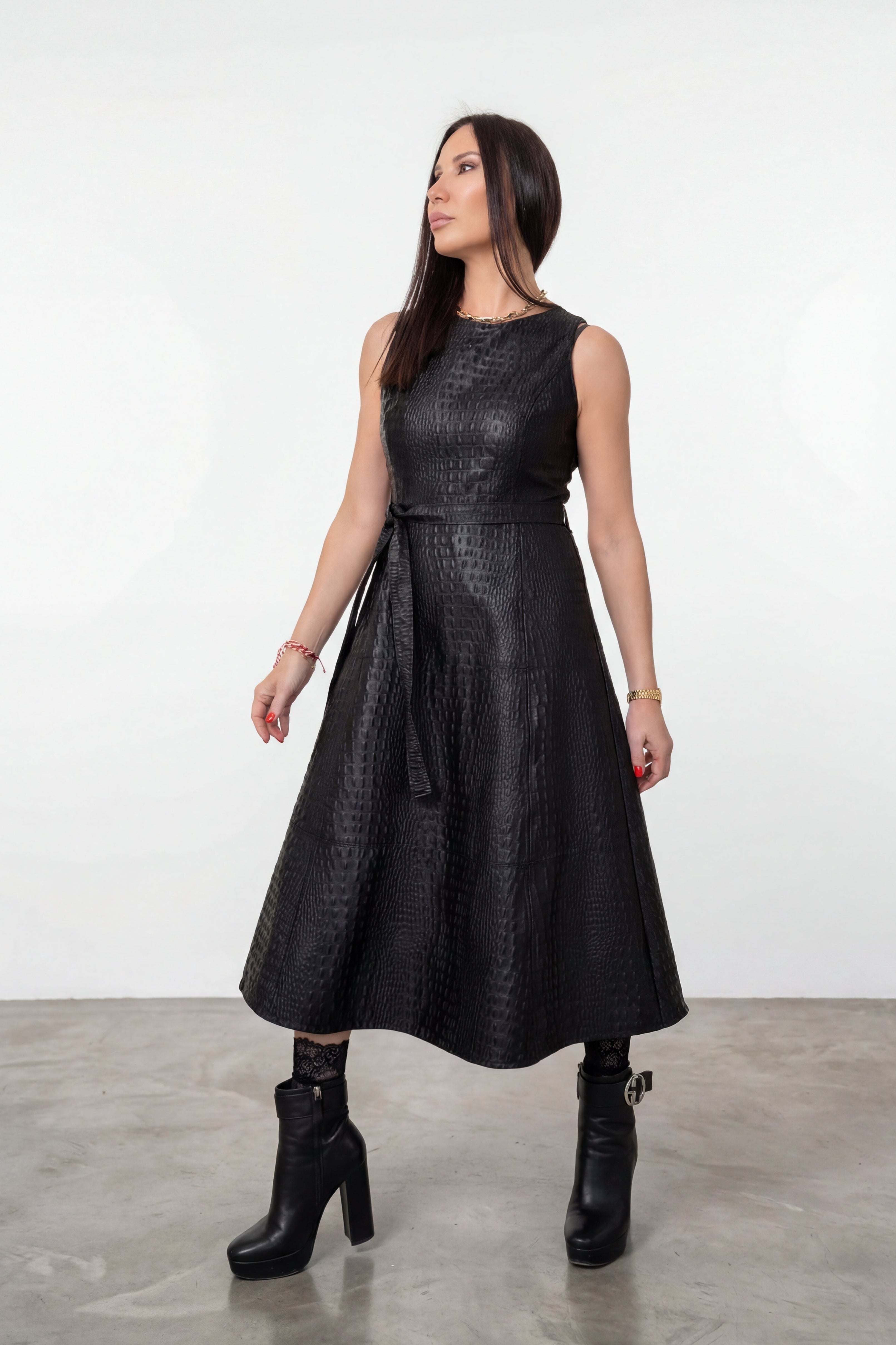 Woman wearing a black dress standing against a white background