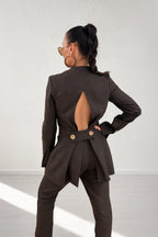 Woman wearing a brown suit with cut-out design on a white background