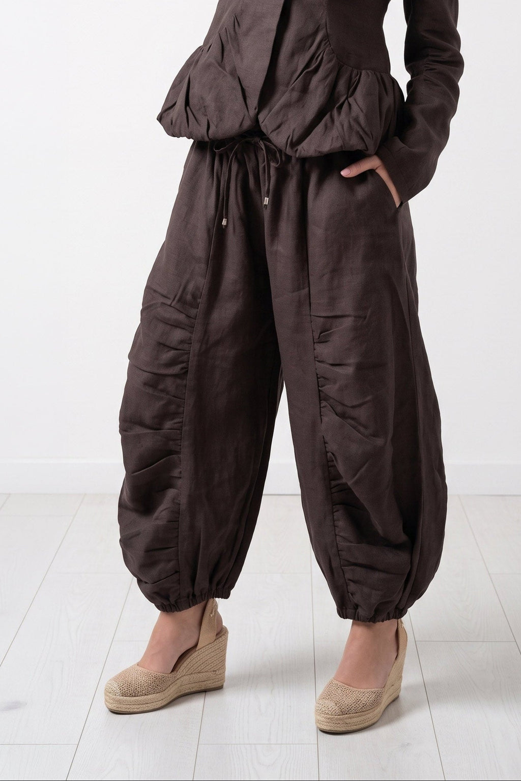 Woman wearing a brown jumpsuit on a white background