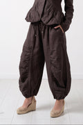 Woman wearing a brown jumpsuit on a white background