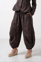 Woman wearing a brown jumpsuit on a white background