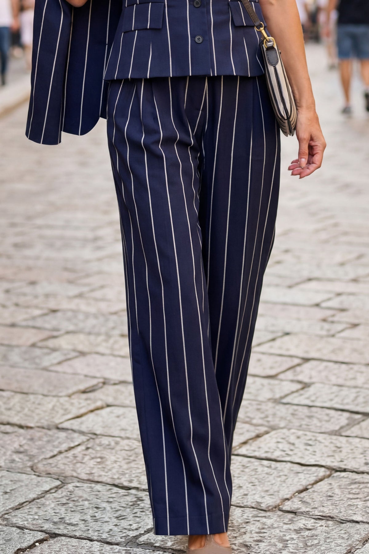 A person wearing navy blue pinstripe trousers 
