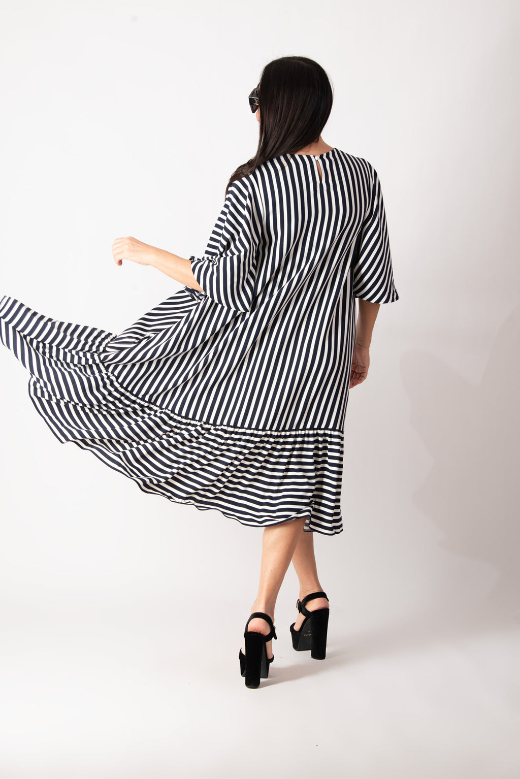 Woman wearing a black and white striped dress on a white background