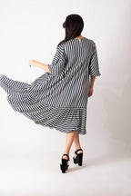 Woman wearing a black and white striped dress on a white background