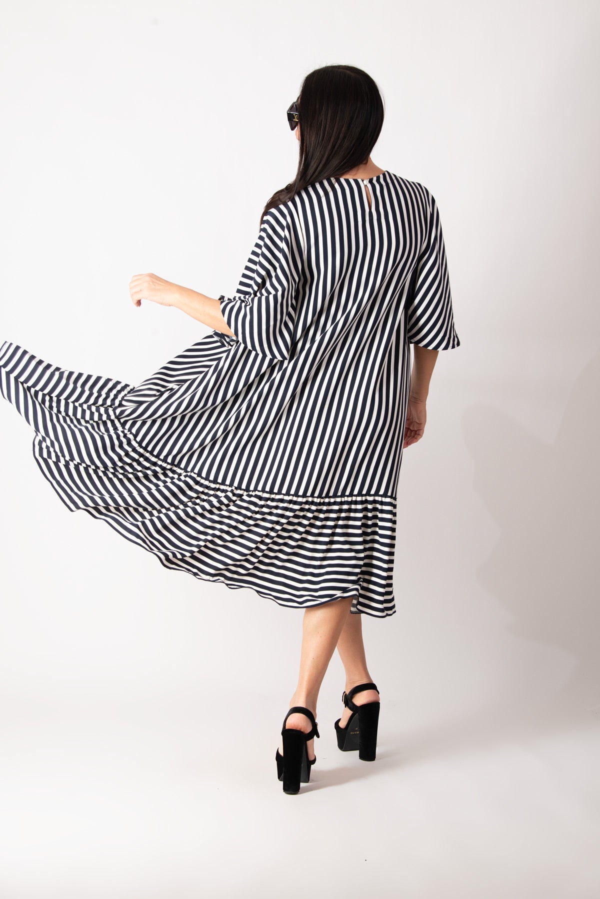 Woman wearing a black and white striped dress on a white background