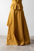 Mustard yellow dress with a wide skirt and fitted bodice on a white background