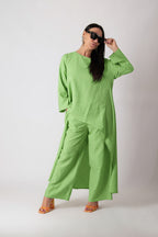 Person wearing a green outfit with sunglasses on a white background