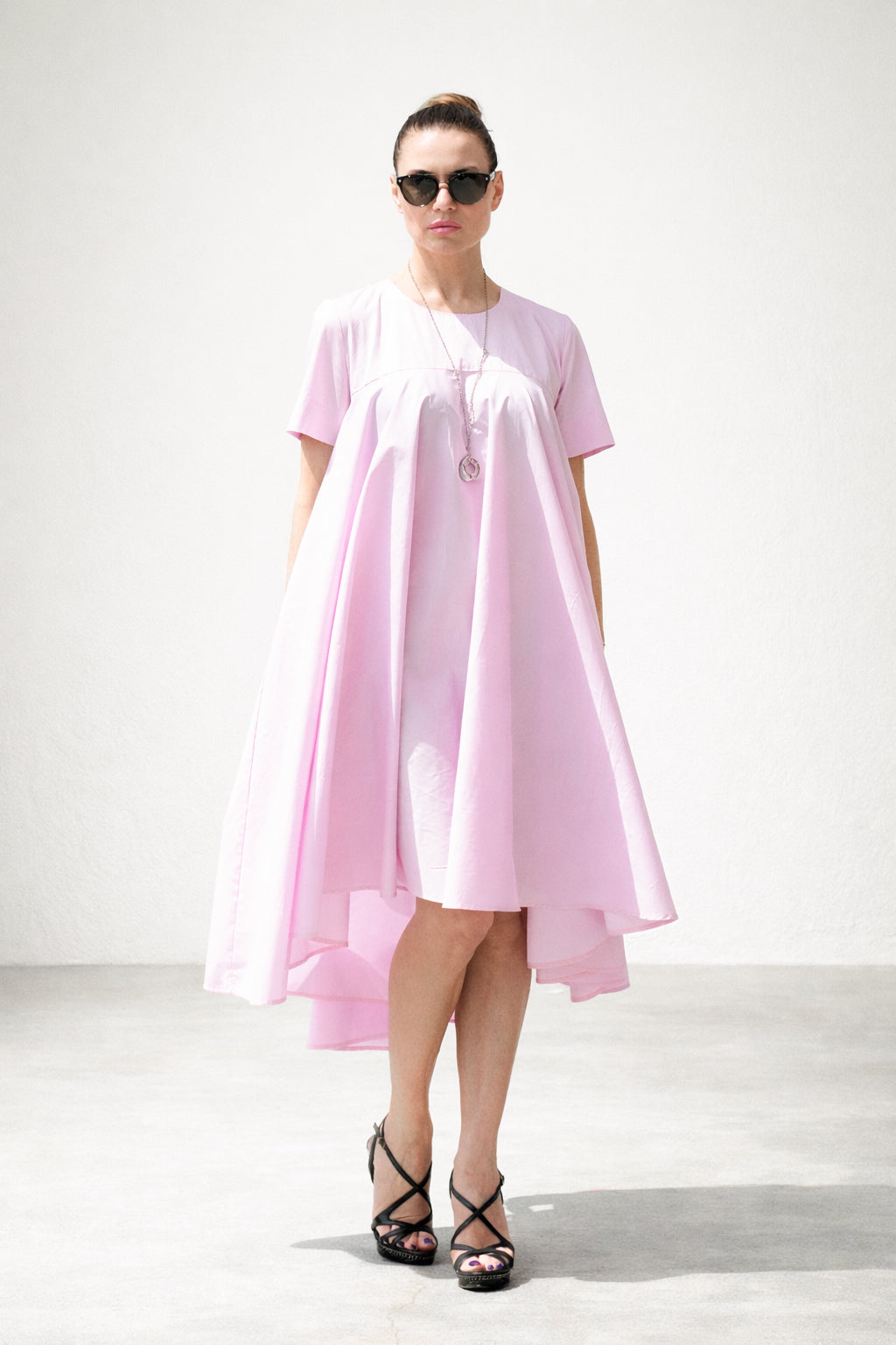 Woman wearing a pink dress with a white background