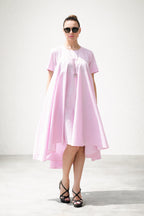 Woman wearing a pink dress with a white background