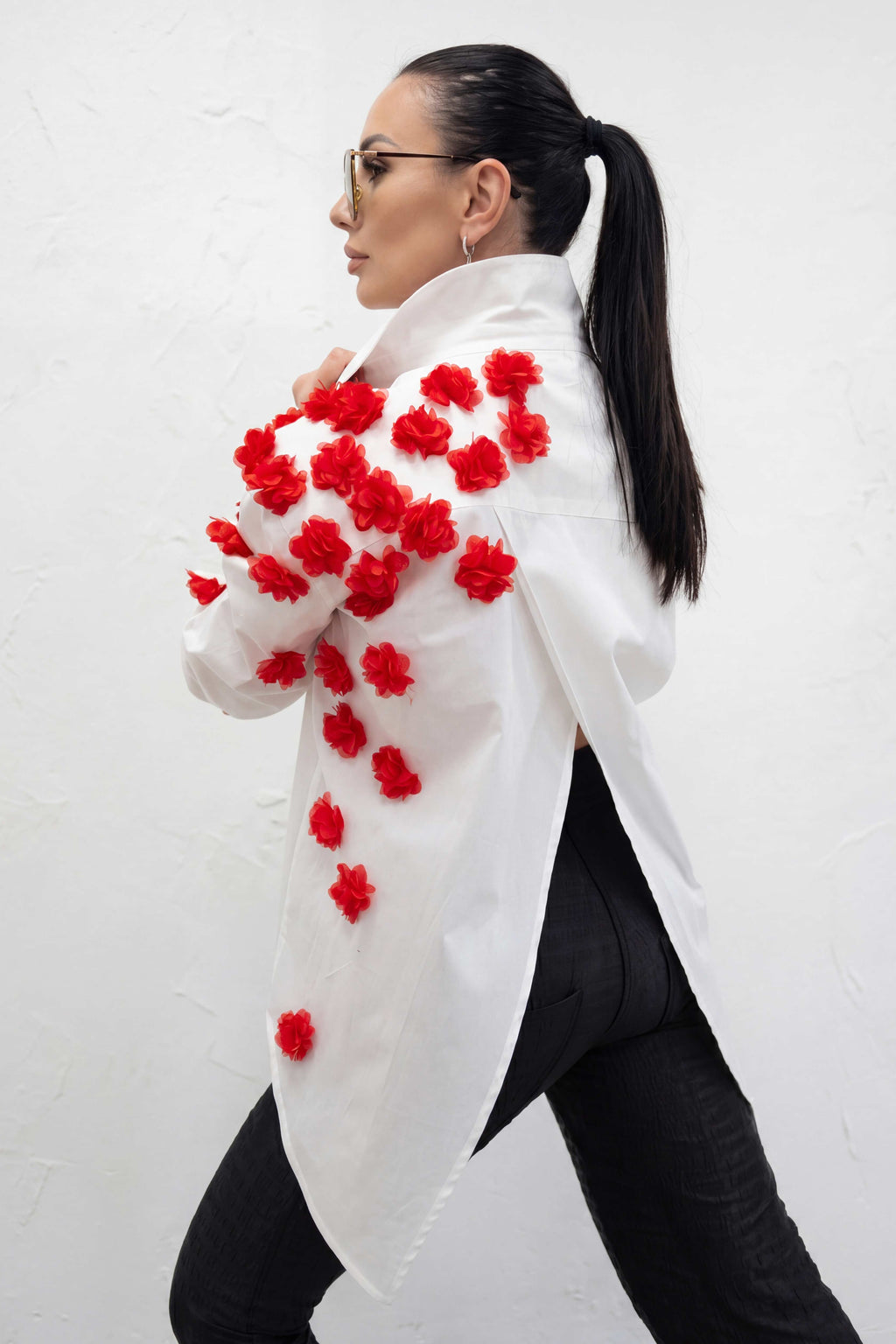 Woman wearing a white coat with red floral patterns on a white background