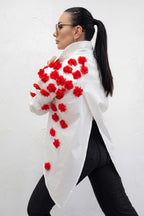 Woman wearing a white coat with red floral patterns on a white background