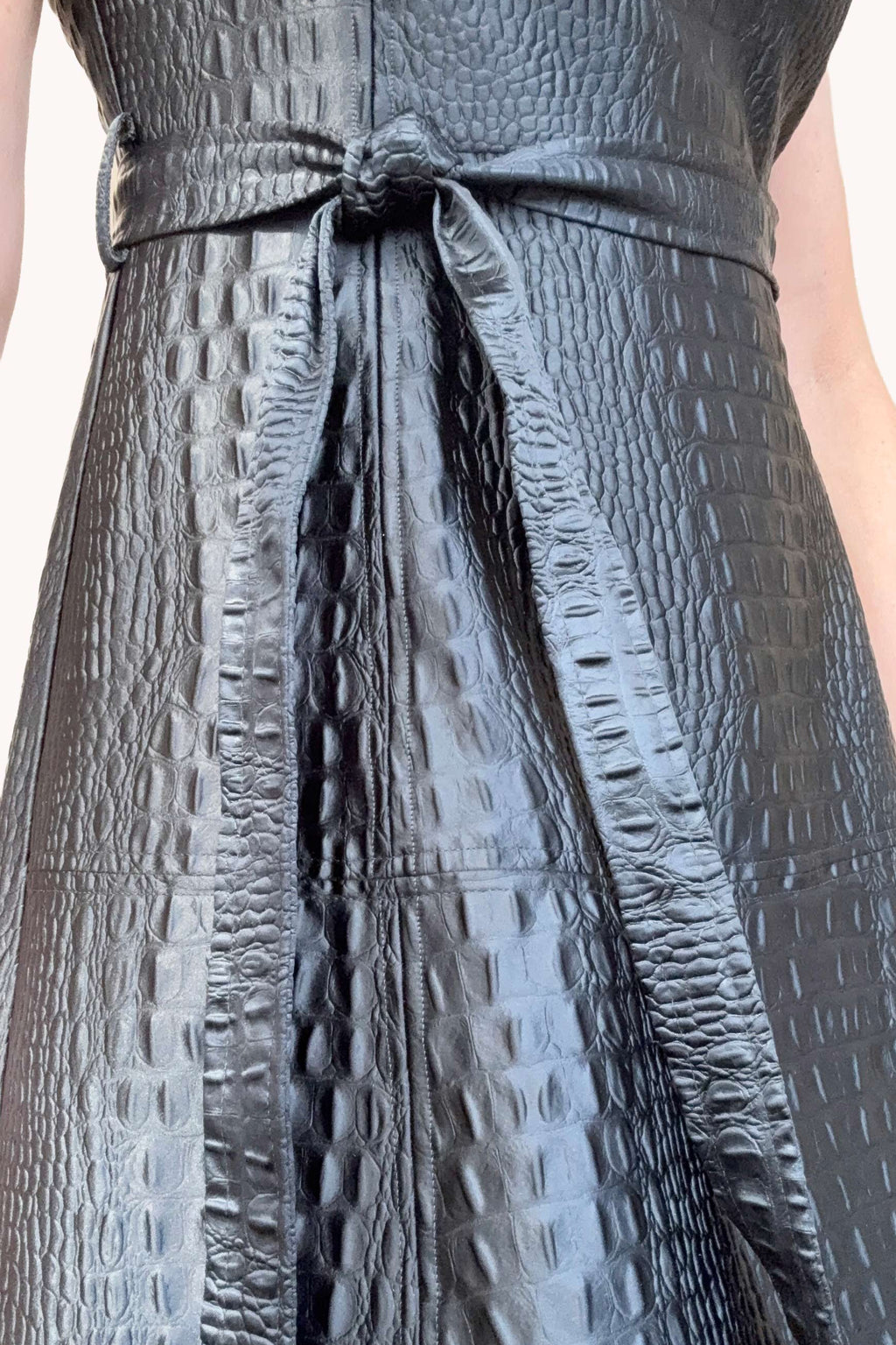 Close-up of a textured gray dress with a belt