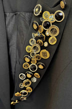 Close-up of a black coat with gold buttons and decorative elements.