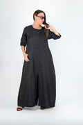 Woman wearing a black long jumpsuit on a white background