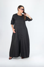 Woman wearing a black long jumpsuit on a white background