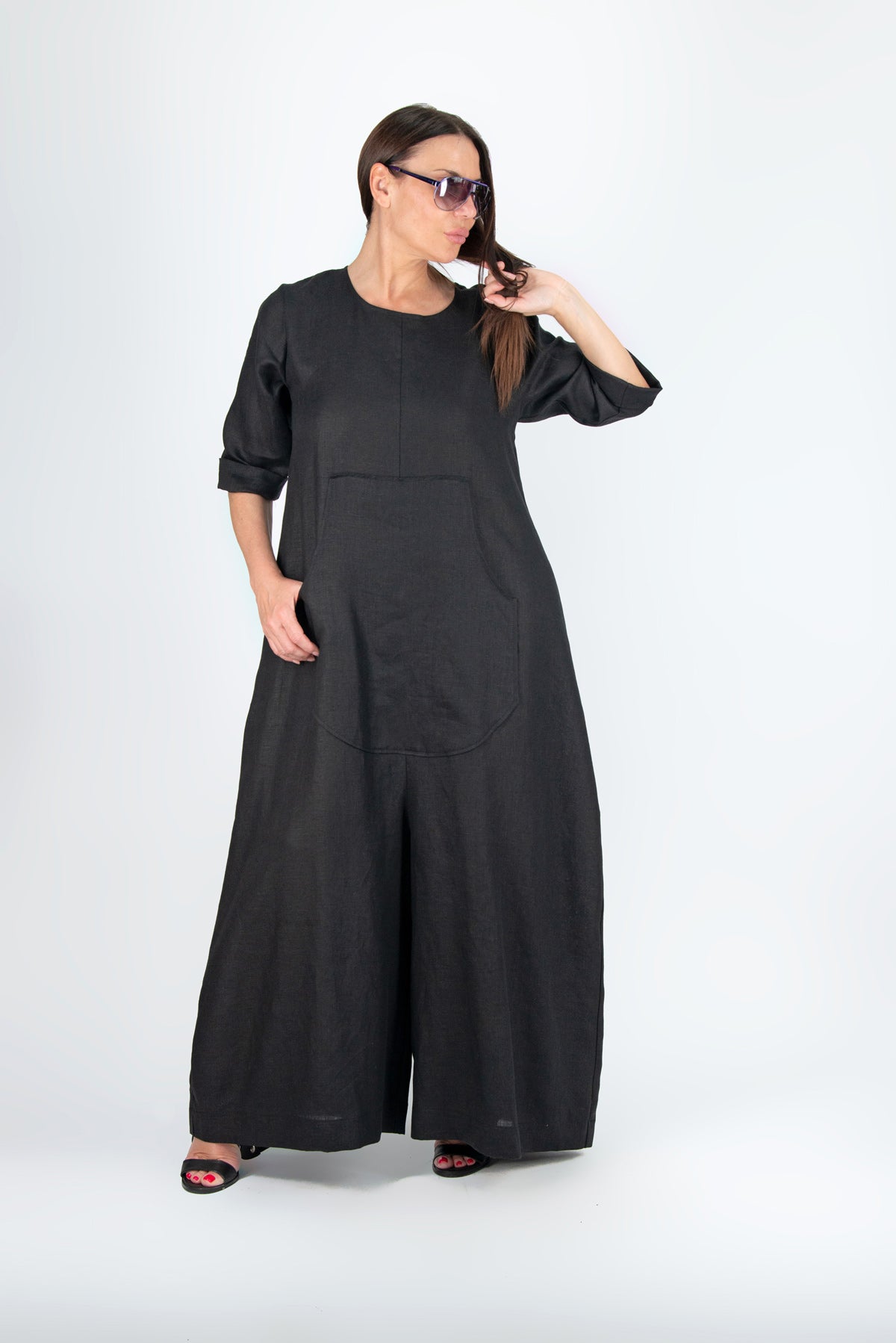 Woman wearing a black long jumpsuit on a white background