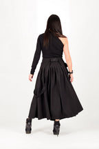 Person wearing a black dress with a belt on a white background