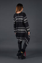 Woman wearing a black and gray plaid dress on a gray background