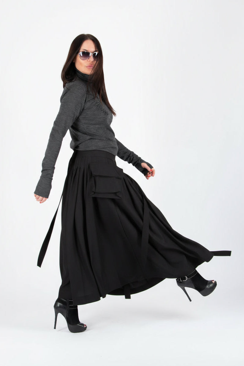 Woman wearing a gray long-sleeve top and black skirt on a white background