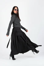 Woman wearing a gray long-sleeve top and black skirt on a white background