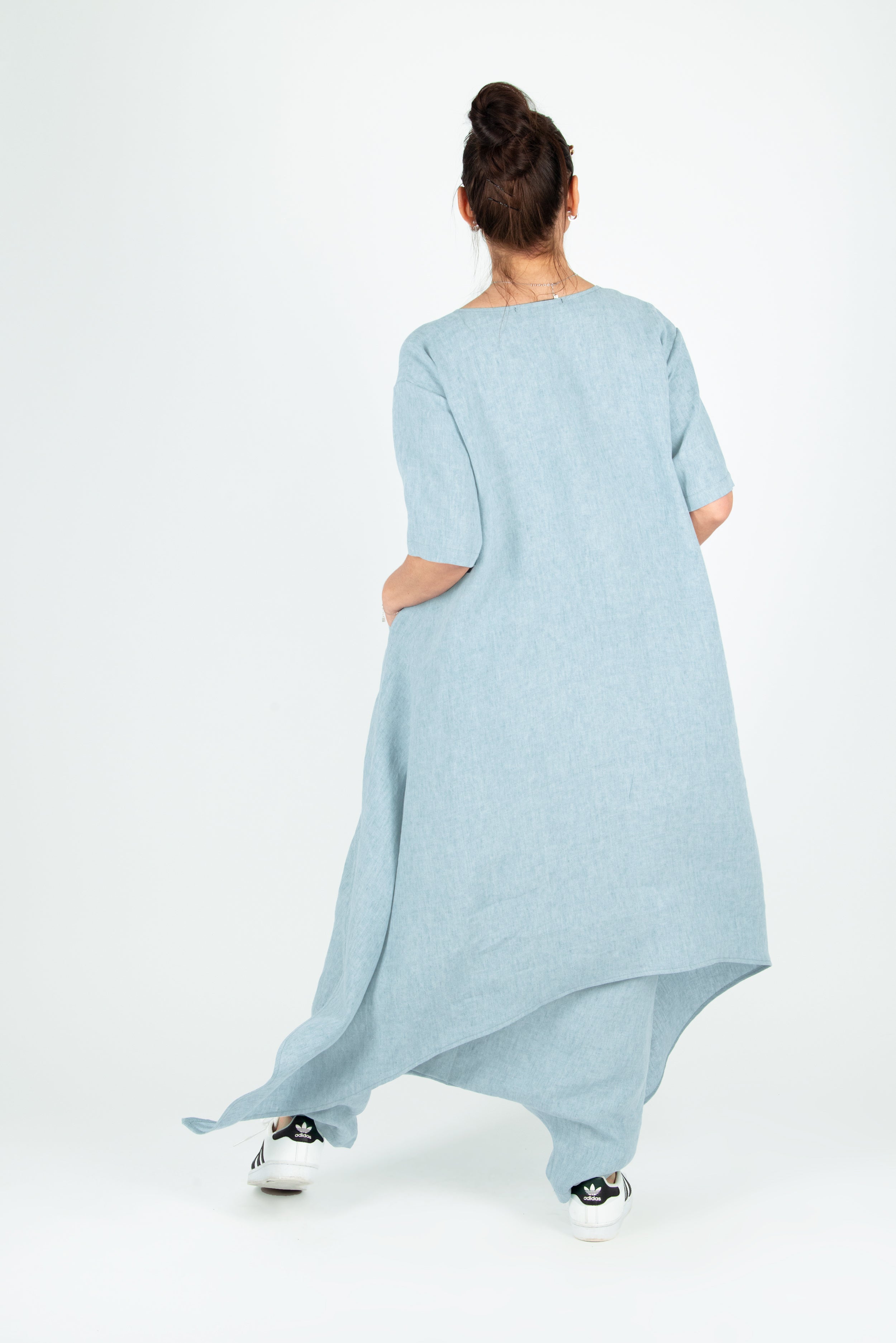 Woman wearing a light blue dress with an asymmetrical hem on a white background
