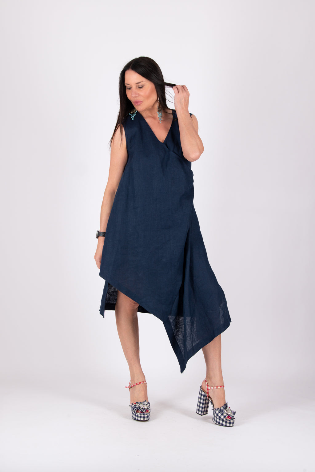Woman wearing a navy blue sleeveless dress on a white background