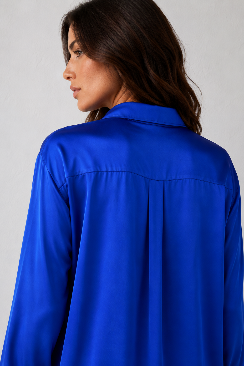 Woman wearing a blue shirt against a gray background