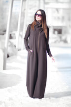 Woman wearing a long dark gray dress in a snowy landscape