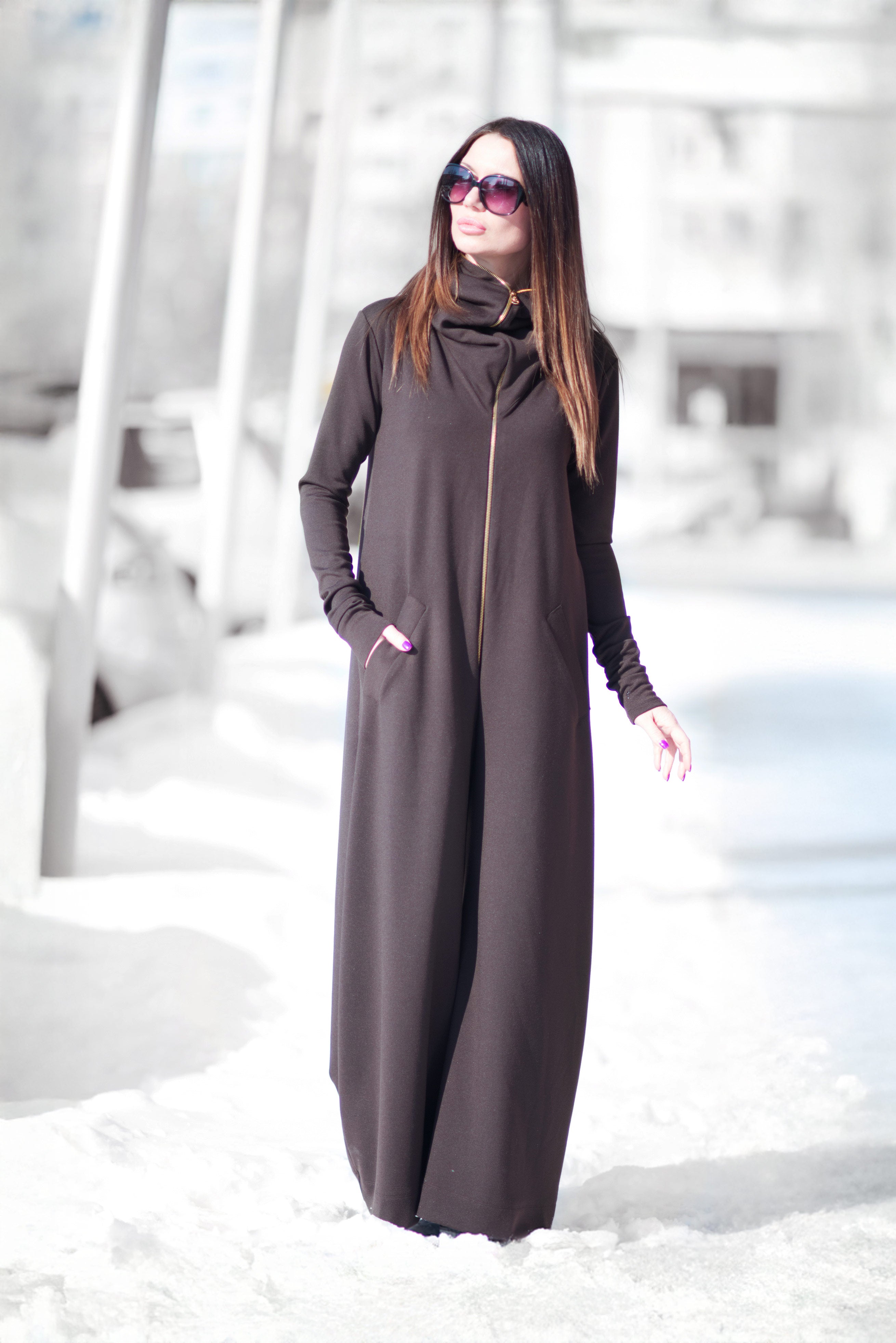 Woman wearing a long dark gray dress in a snowy landscape