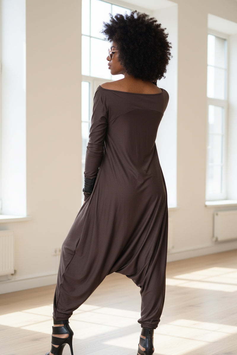 Person wearing a long brown dress in a bright room with large windows.
