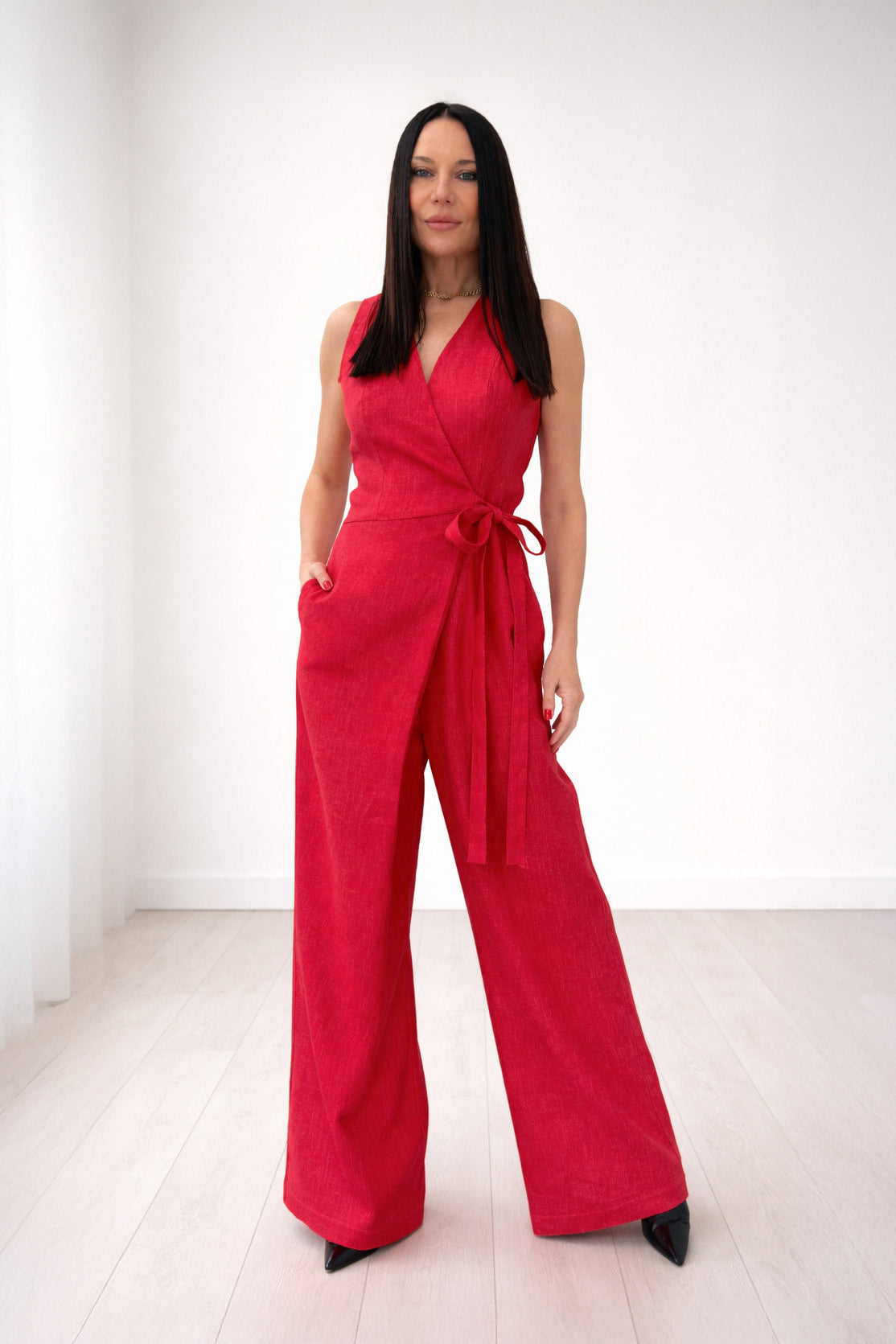 Woman wearing a red jumpsuit against a white background