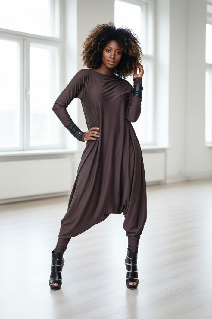 Woman wearing a brown long-sleeve dress in a bright room.