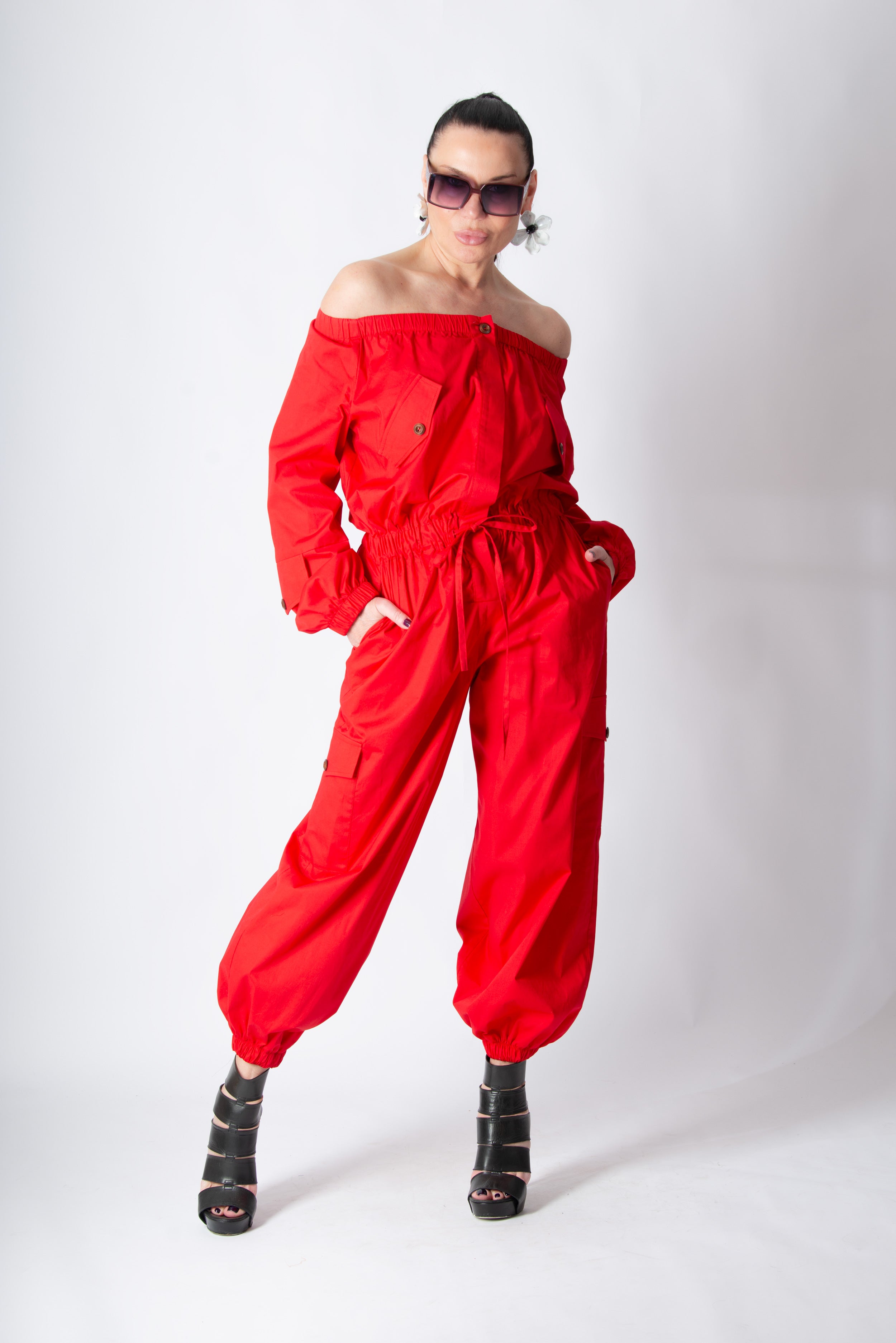 Person wearing a red outfit with black shoes on a white background