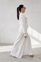 Woman in a white outfit standing against a light background