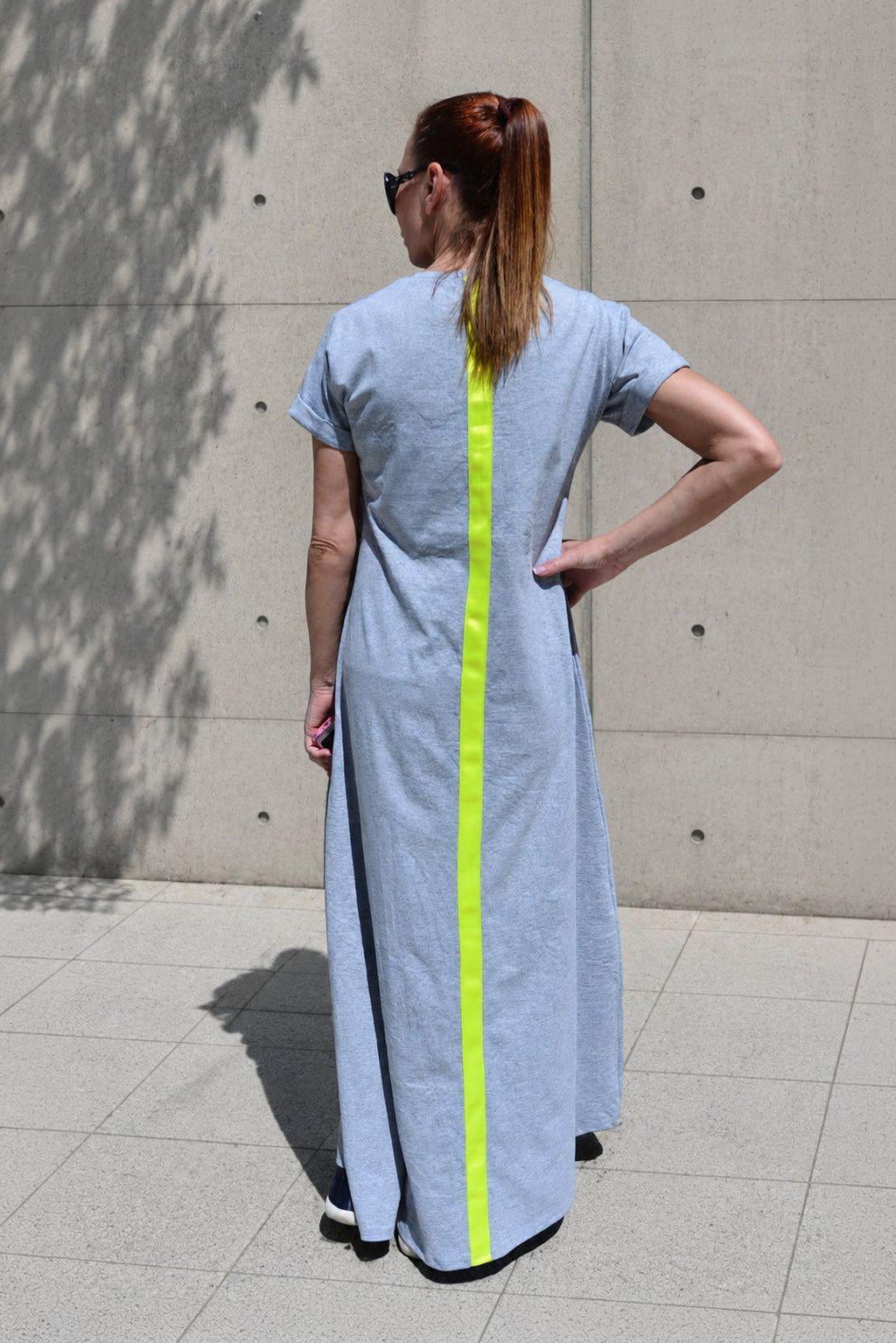 Woman wearing a light grey dress with a yellow stripe