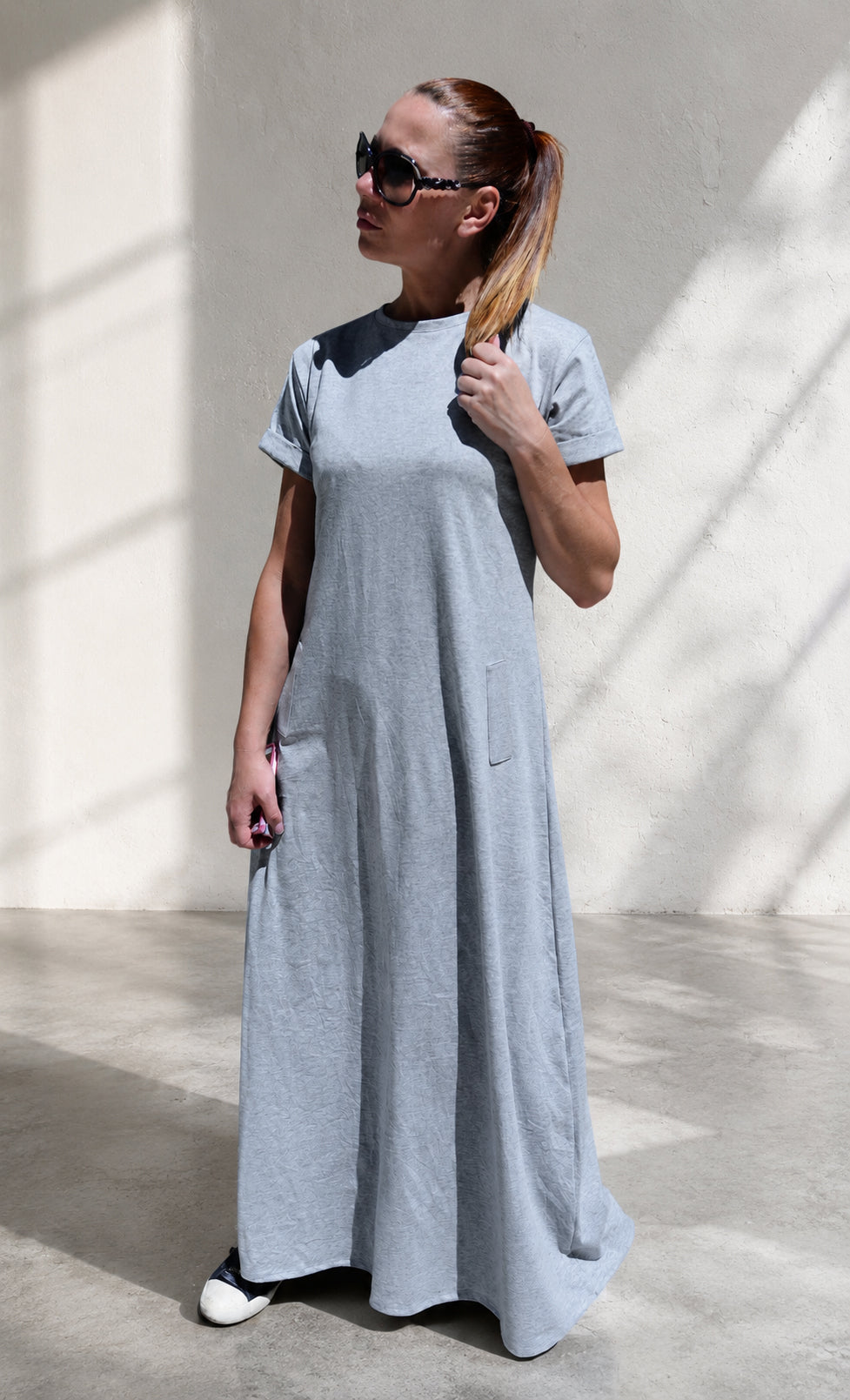 Woman wearing a long gray dress with 