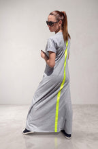 Woman wearing a gray dress with a neon green stripe on the back