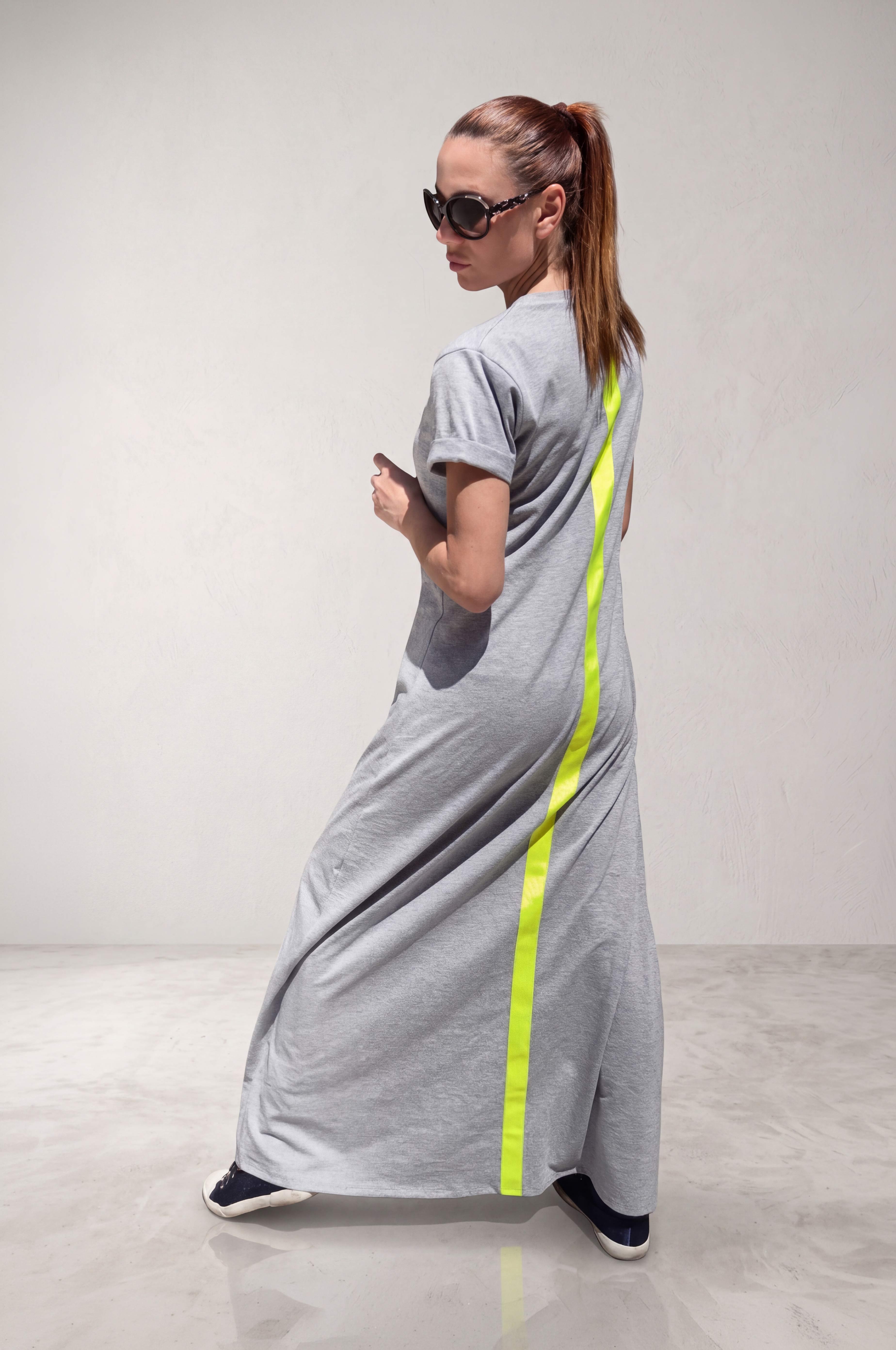 Woman wearing a gray dress with a neon green stripe on the back