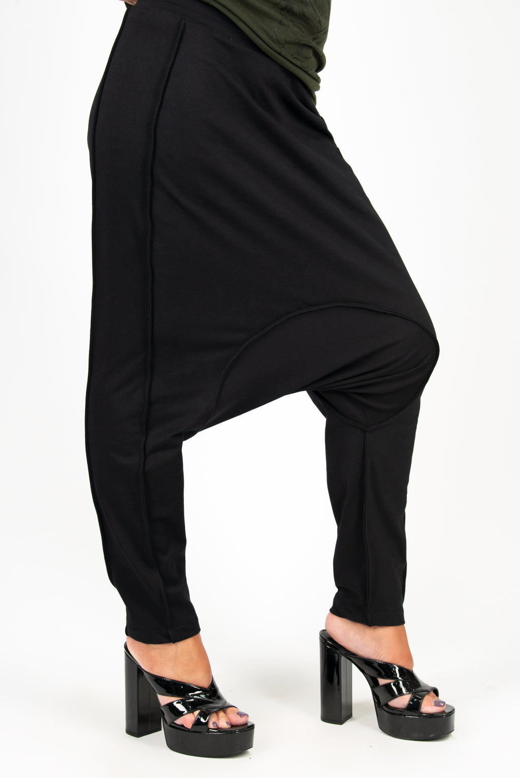 Black harem pants worn by a person on a white background