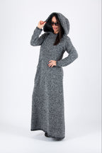 Person wearing a long gray hooded dress on a white background