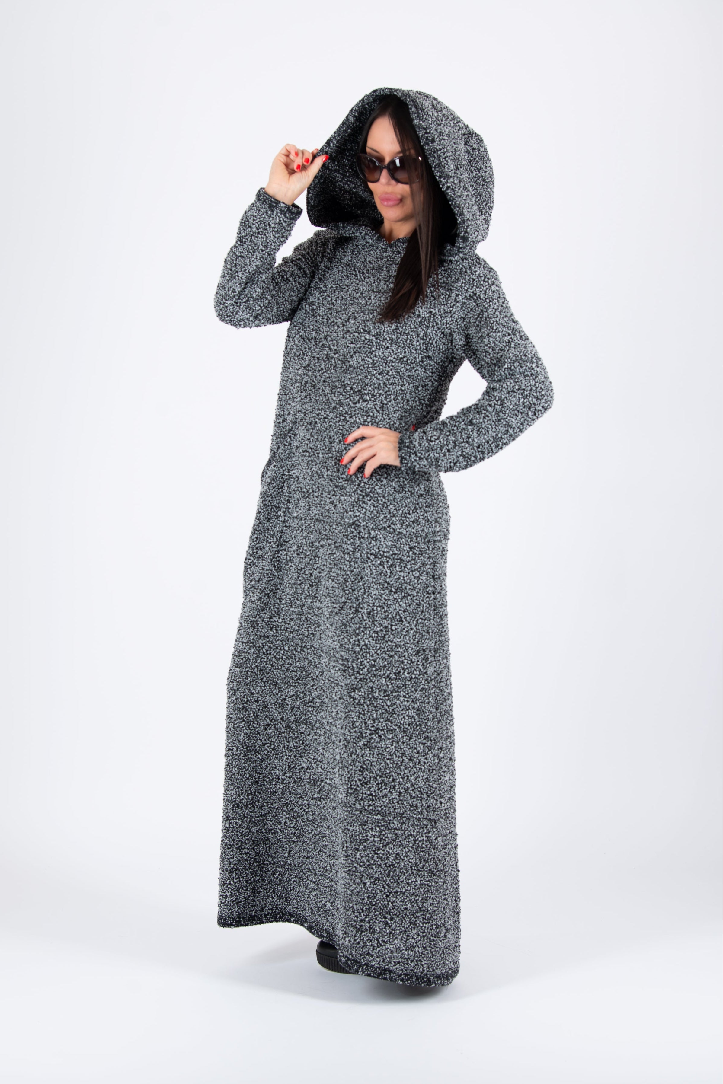 Person wearing a long gray hooded dress on a white background