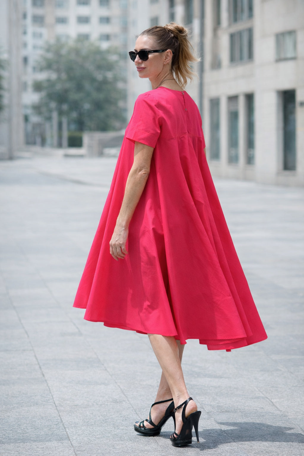 Woman wearing a bright pink dress in an urban setting