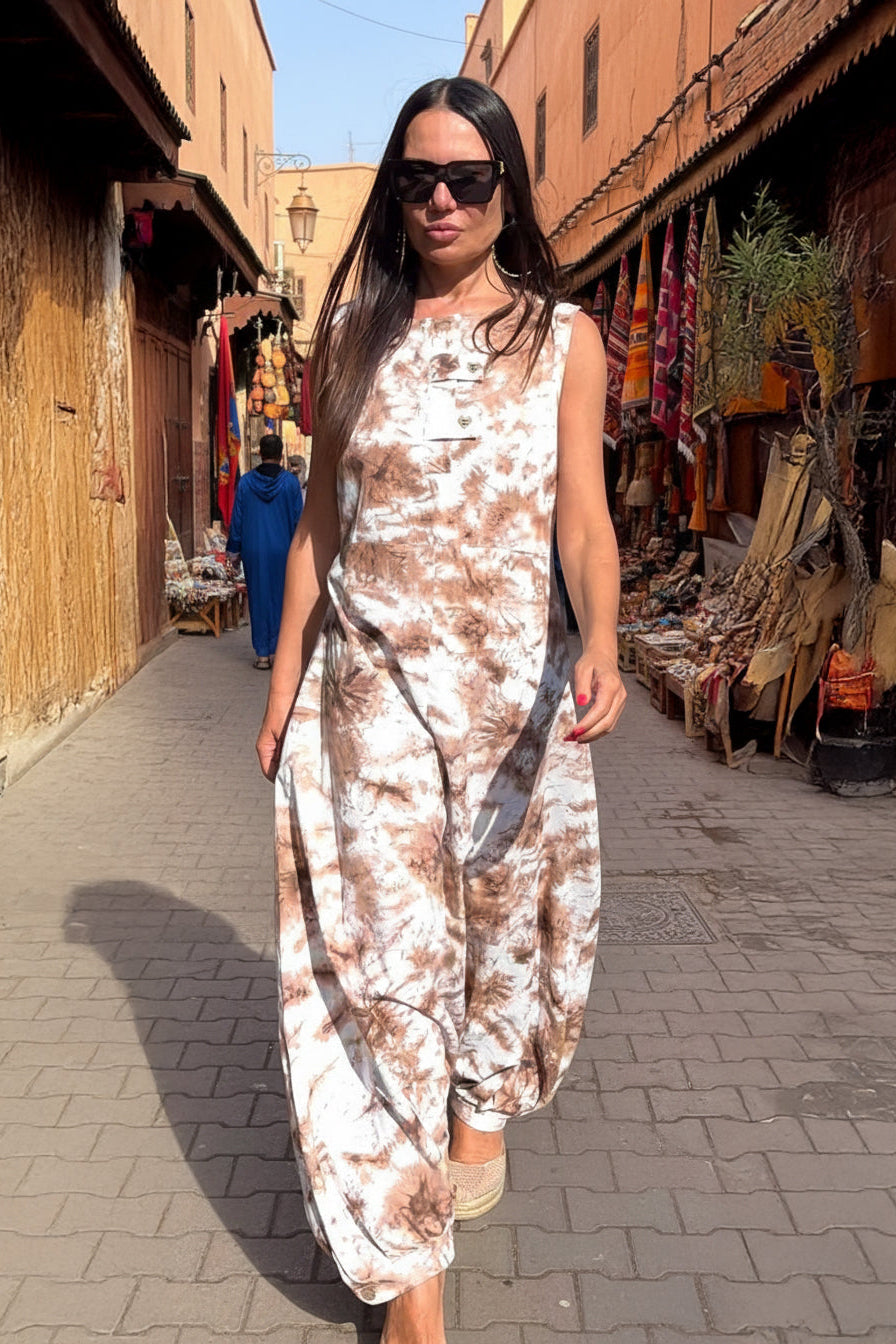 Woman in a floral dress standing in a market alleyway.