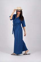 Woman wearing a blue dress and beige hat on a white background