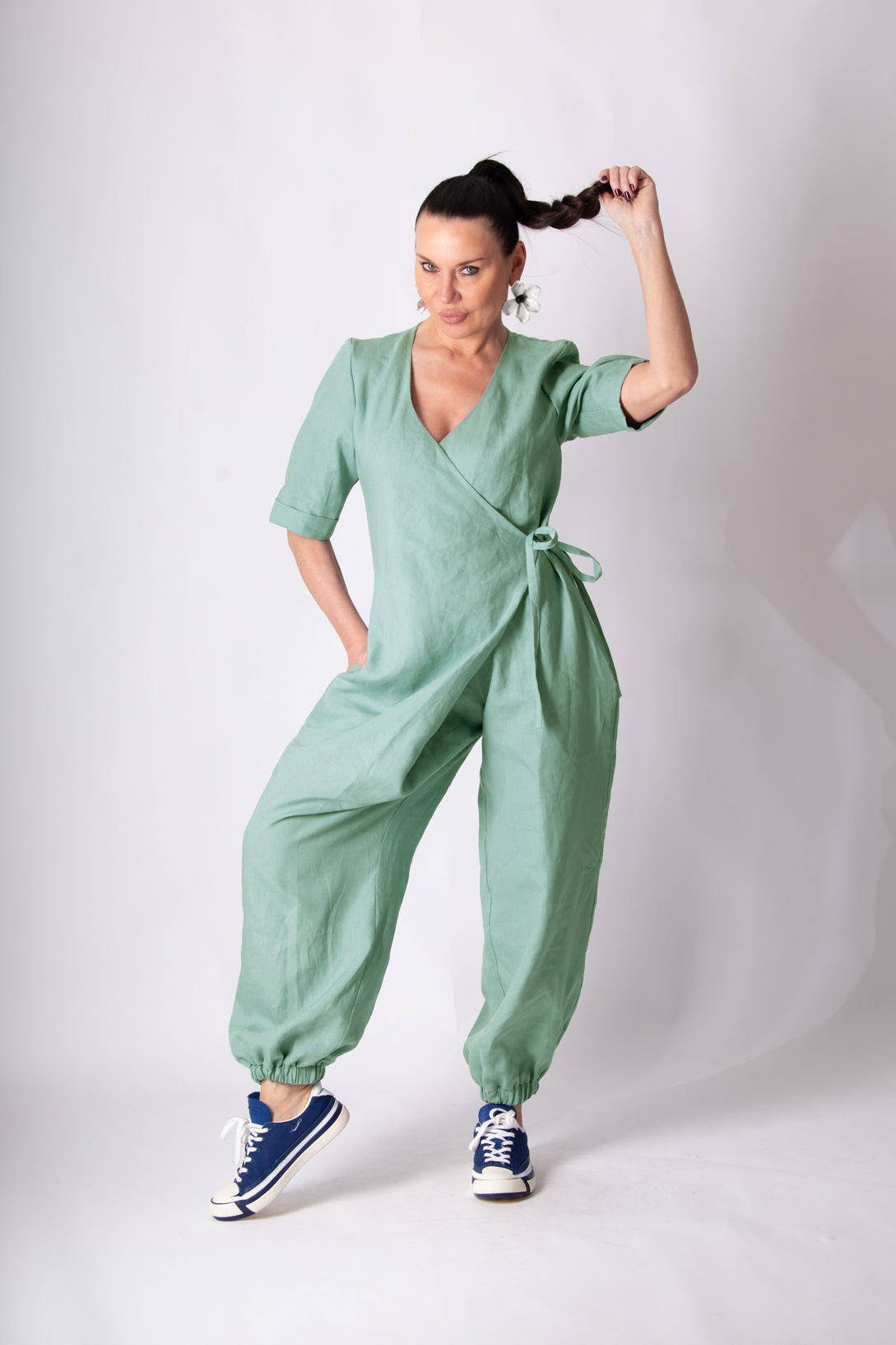 Woman wearing a green jumpsuit on a white background