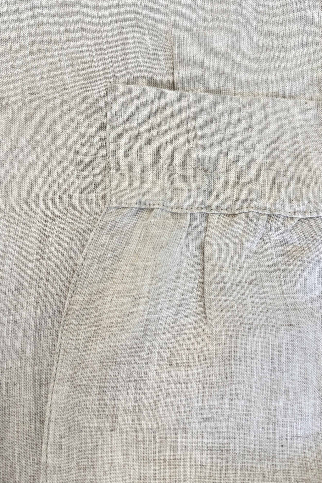Close-up of beige fabric with a pocket detail