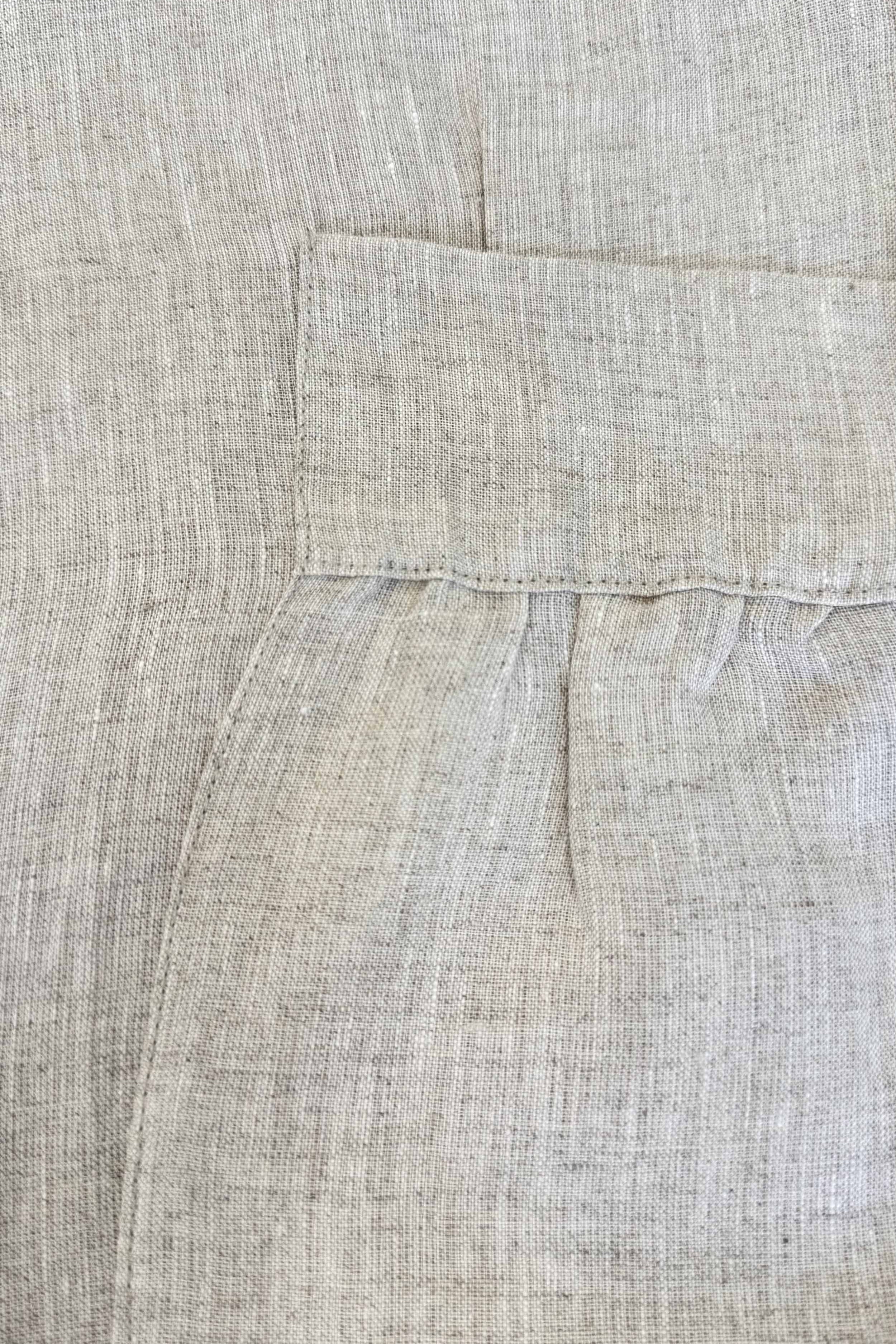 Close-up of beige fabric with a pocket detail